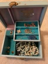 Blue jewelry box with costume, jewelry, like pearl, necklaces across necklace, pennant, and chain