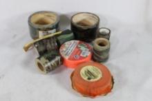 Two red rolls of flagging tape and six rolls of camo tape. Some in packages.