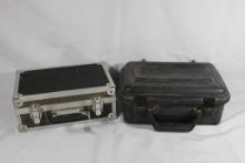 Two foamed pistol boxes. One black plastic and one metal. Used.
