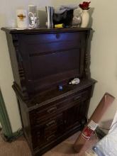 Brown wooden cabinet with mixed items