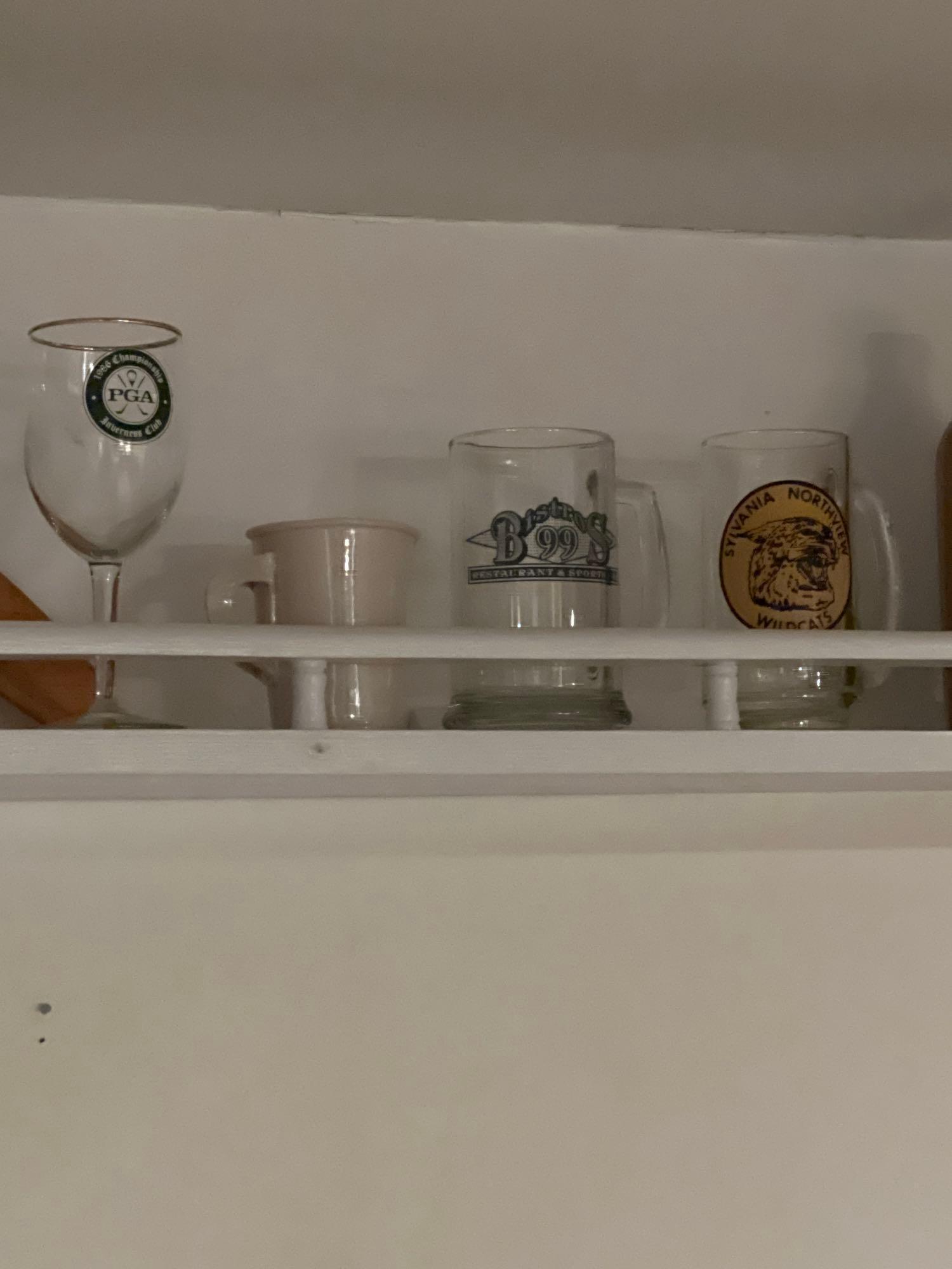 long shelf with bobbleheads mugs steins and more