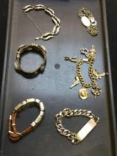 Group of various bracelets, including charm bracelet