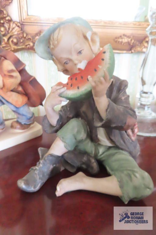 Hummel figurine and boy eating watermelon figurine, both have chips