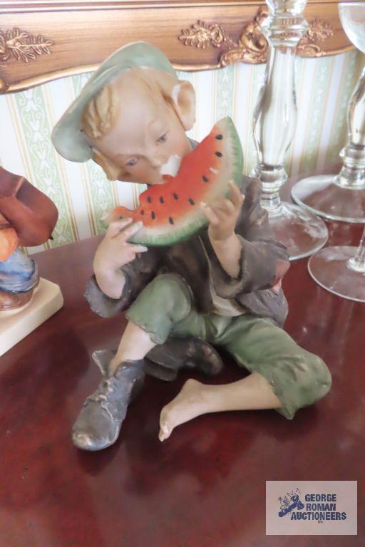 Hummel figurine and boy eating watermelon figurine, both have chips