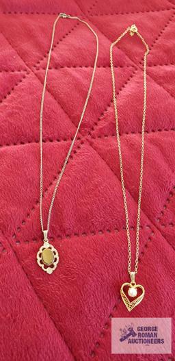 Gold colored heart-shaped pendant with pearl like stone on gold colored chain, both marked 120 14K