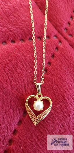 Gold colored heart-shaped pendant with pearl like stone on gold colored chain, both marked 120 14K