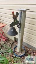 Rooster motif cast iron bell on wooden post with pan