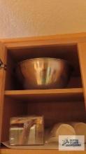 Lot of plastic ware and...colander in the bottom and top right cabinets