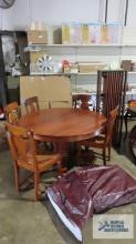 Antique mahogany pedestal table with five rush bottom chairs, table pads, and leaf holder.