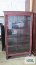 Antique mahogany china cabinet with wooden wheels