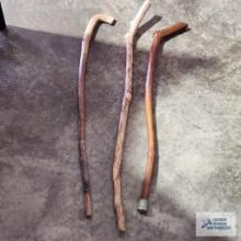Three decorative wooden canes. One has been repaired and is cracked.