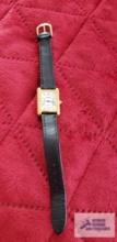 Medana ladies gold colored watch with black band, sellers description reads 10K yellow gold, no