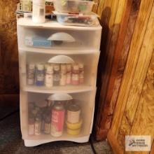 Lot of crafting supplies with roll about three drawer cabinet in basement