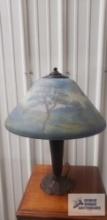Vintage lamp with reverse painted shade. 21 in. tall. Base of shade is 16 in. wide. Has crack in