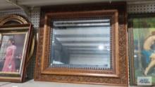 Antique beveled mirror with ornate oak frame. Frame measures 30 in. by 26 in.
