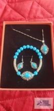 Silver and turquoise colored necklace, earrings, and bracelet set