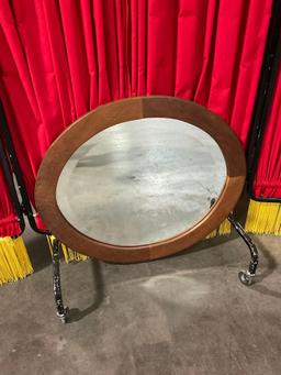 Small oval wood-framed hanging beveled mirror