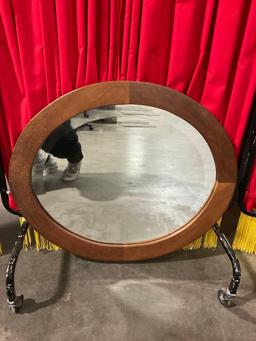 Small oval wood-framed hanging beveled mirror