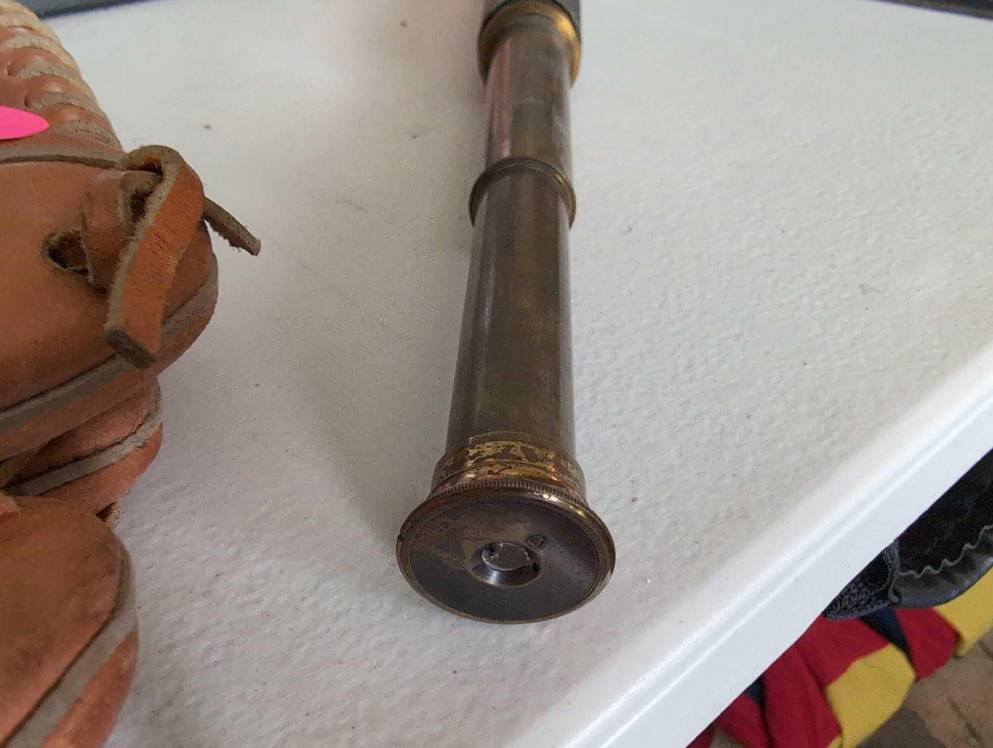 (LR) ANTIQUE BRASS TELESCOPE WITH LEATHER BAND. NOTE, BAND IS COMING OFF. 12" LONG FULLY EXTENDED.
