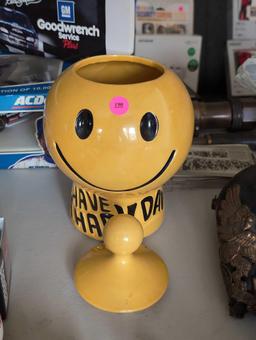 (LR) VINTAGE MCCOY POTTERY "HAVE A HAPPY DAY" SMILING FACE COOKIE JAR. SMALL CHIP ON LID. 11" TALL.