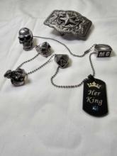 Skull and crossbones silver tone rings on a necklace with a star belt buckle.