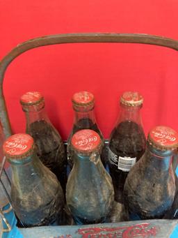 Vintage milk bottles in carrier and vintage Pepsi carrier with Coke bottles