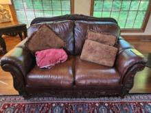 Ashley furniture love seat in faux leather with ornate wooden frame