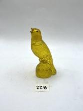 yellow parakeet with some liquid avon bottle