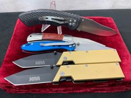 5 Knives from the National Rifle Association, 2x Brass Acronym grip, 1x aluminum, 1x rubber, 1x w...