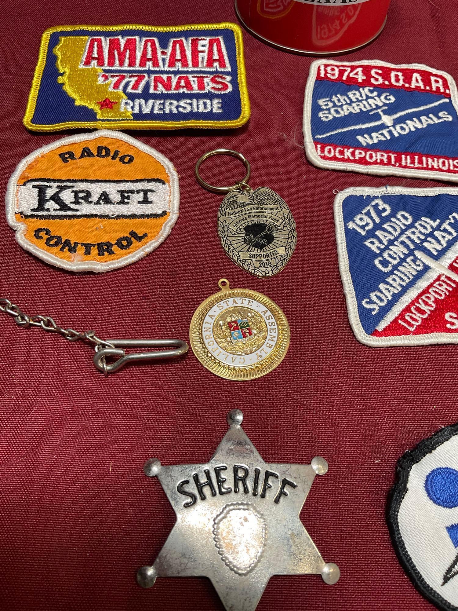 Assorted badges, Sheriff star, stamped Military whistle, key chain, pendant, piggy bank. 15 pieces